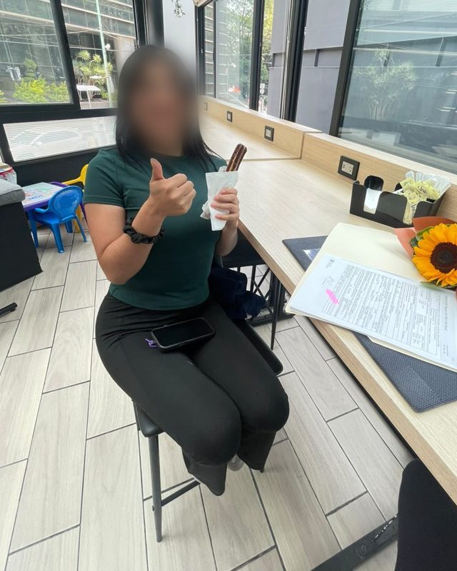 Clienta con el pulgar arriba junto a su solicitud firmada, rostro difuminado